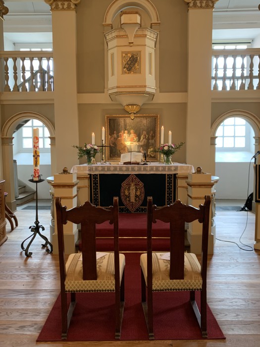 Zwei Stühle vor dem Altar in einer Kirche