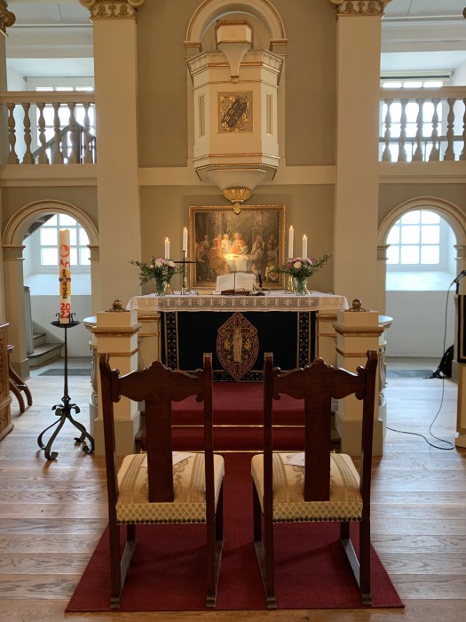 Zwei Stühle vor dem Altar in einer Kirche